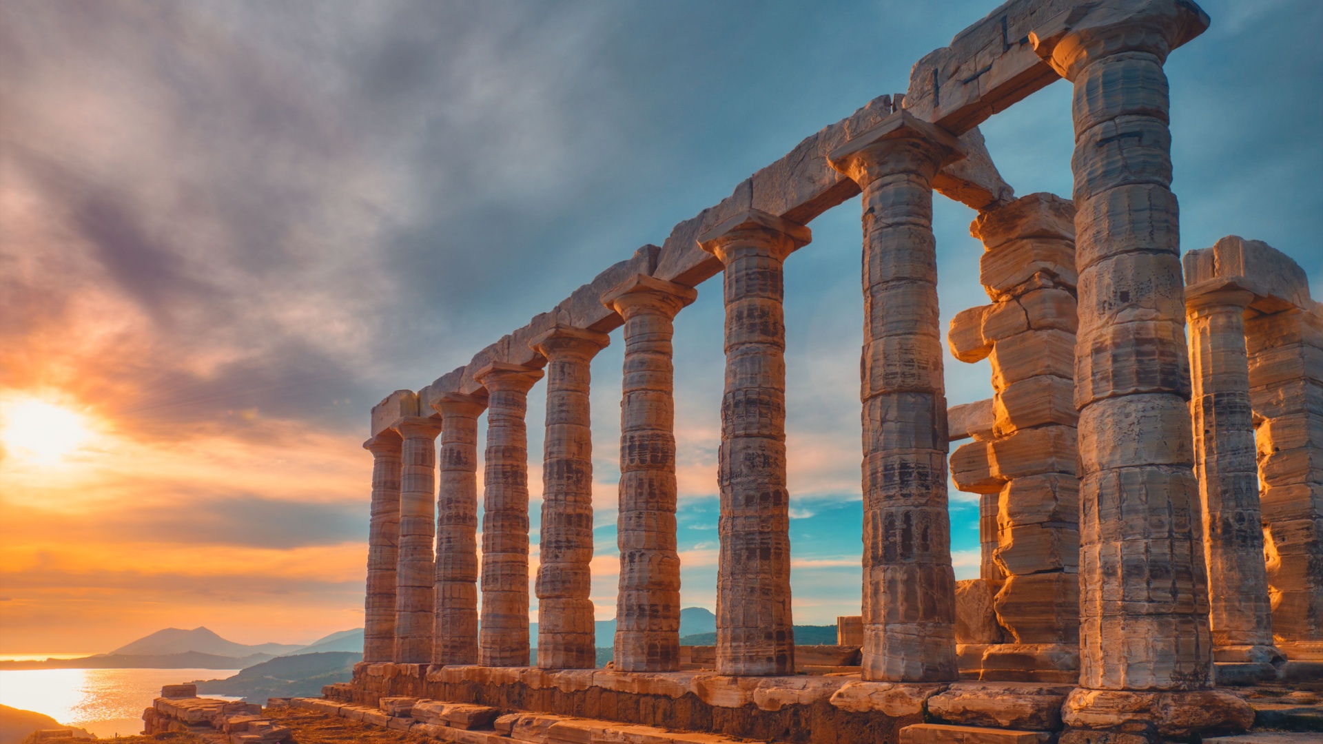 Temple of Poseidon at Cape Sounio, glowing at sunset over the Aegean
