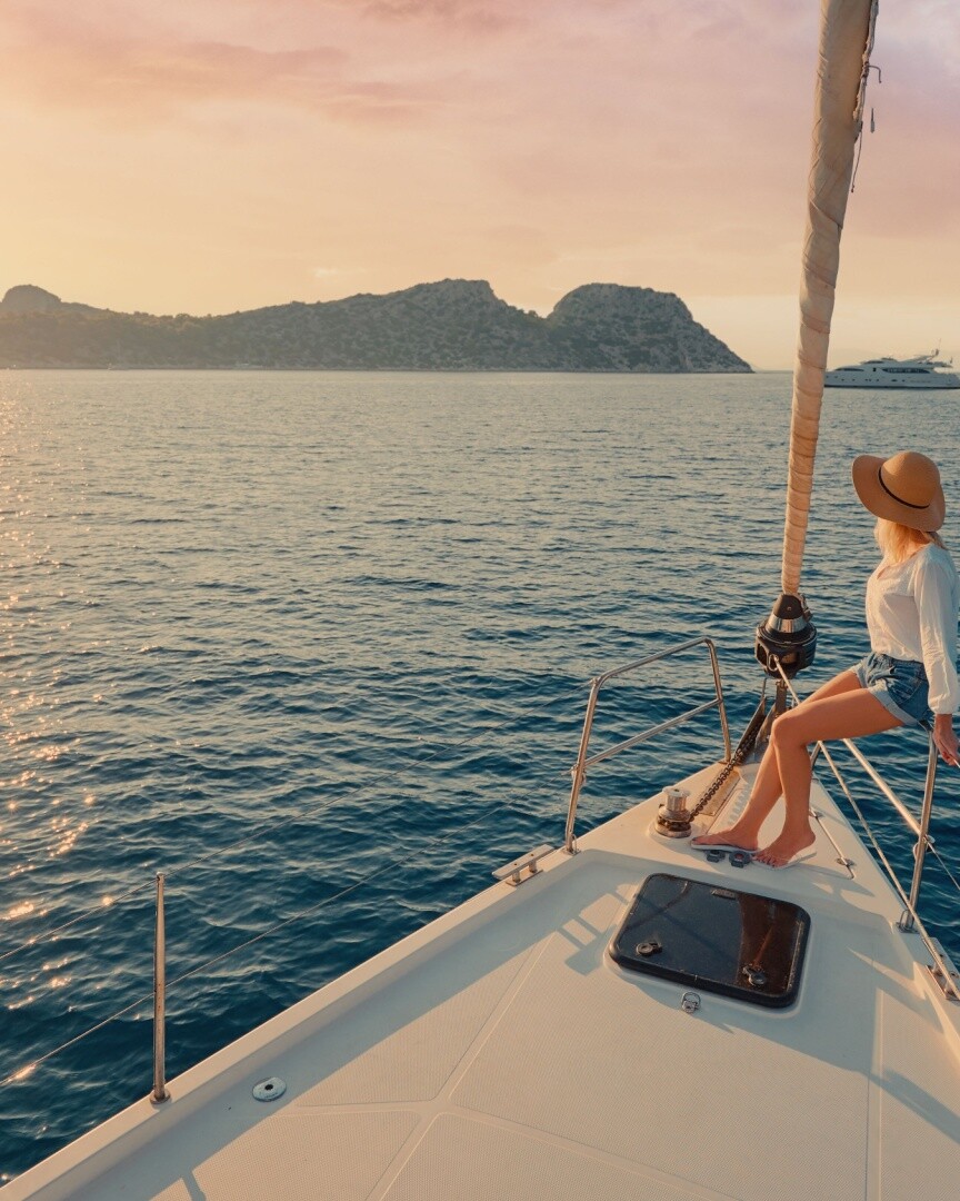 A traveller aboard a private yacht at sunset over the Aegean Sea